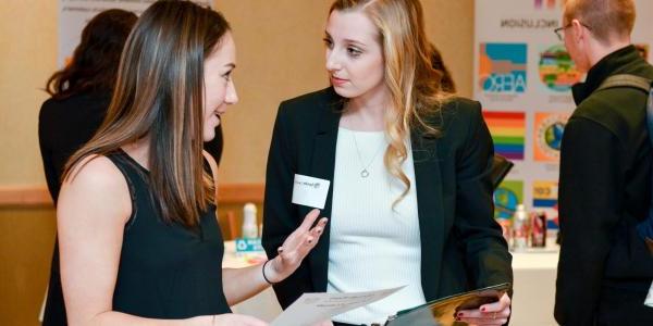 a business school student engaged with a corporate partner at a recruitment event