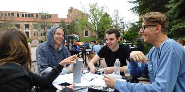 group of students studying at an outdoor table